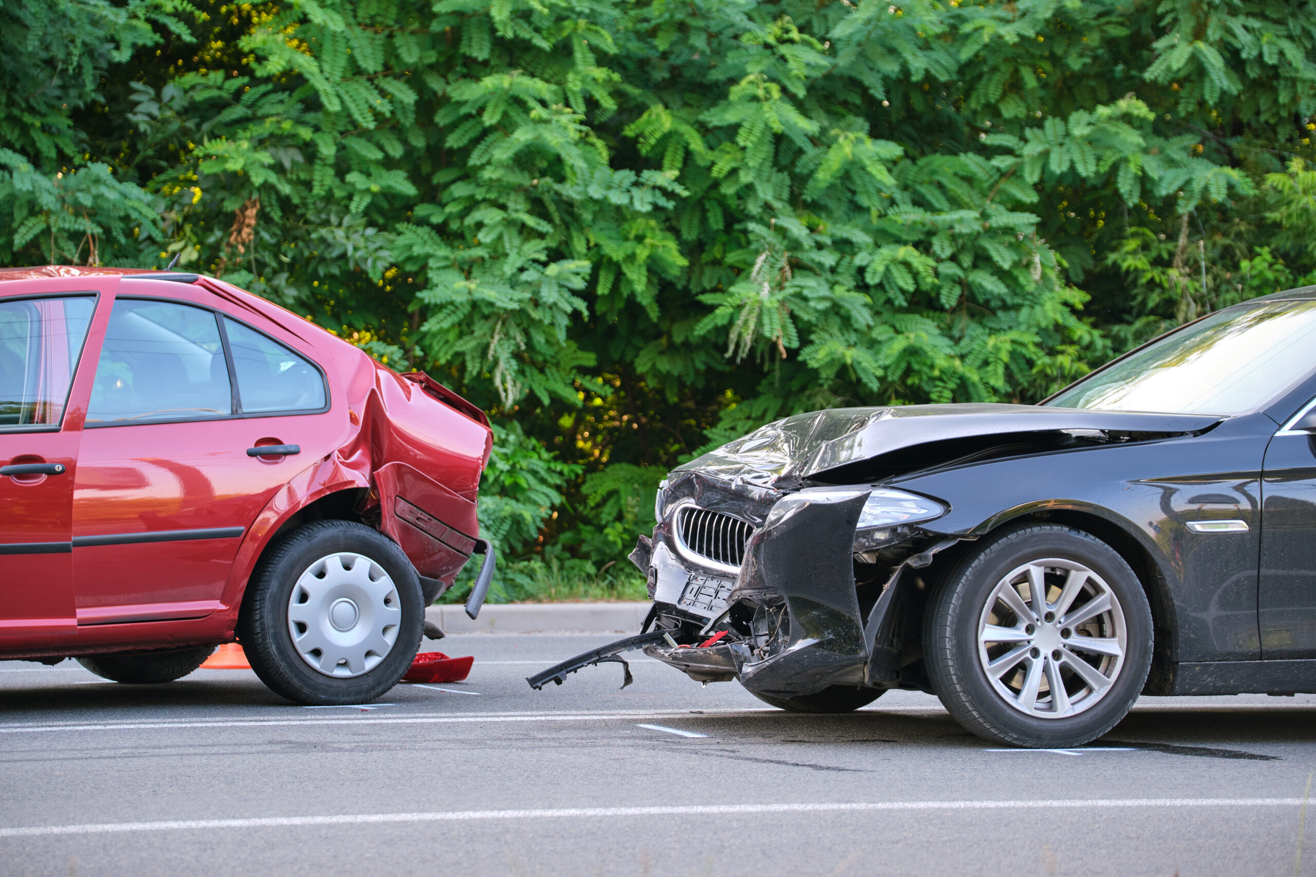 Damaged in heavy car accident vehicles after collision on city street crash site. Road safety and insurance concept.